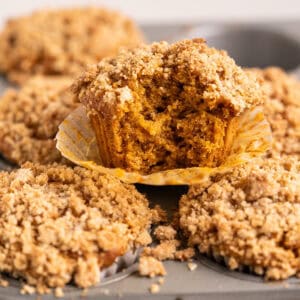 The inside of a gluten-free vegan pumpkin muffin to show the layers of moist pumpkin muffin and crisp streusel topping.
