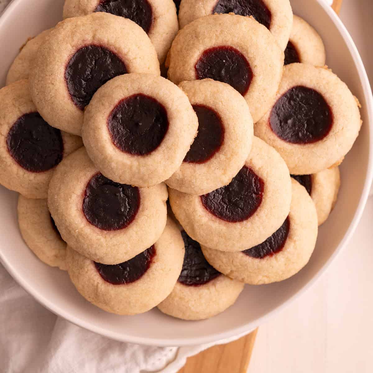 A serving plate stacked with gluten-free thumbprint cookies.