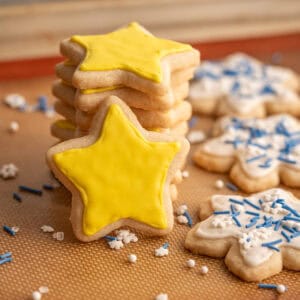 A star cookie covered in yellow vegan royal icing.