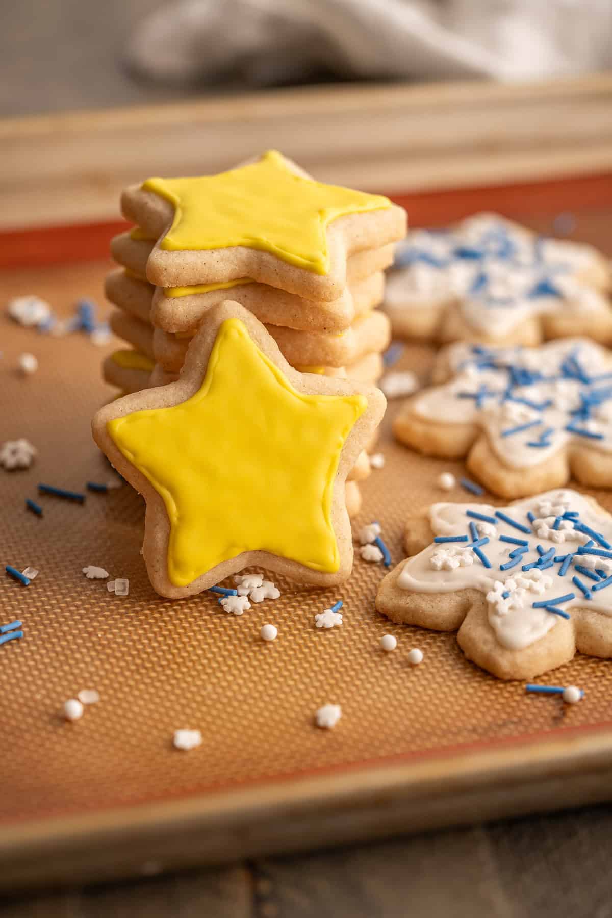 A star cookie covered in yellow vegan royal icing.