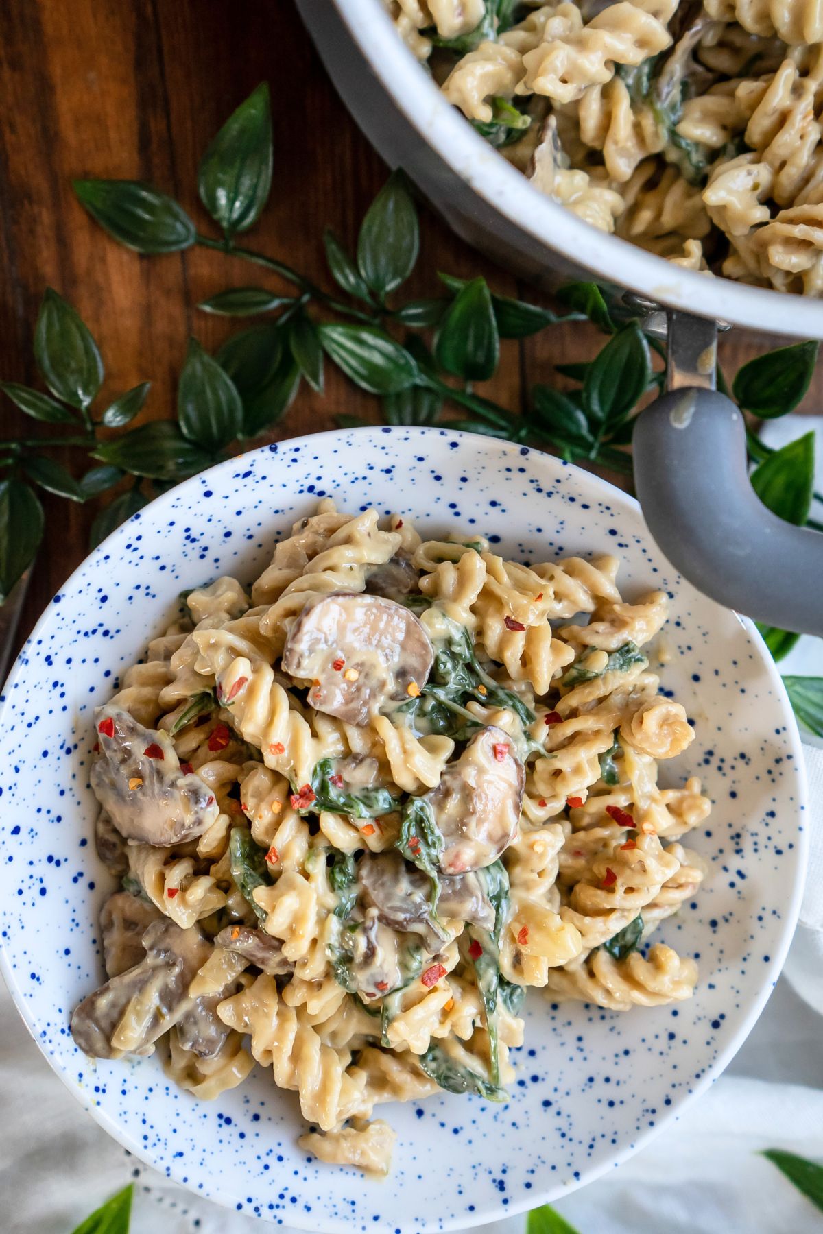 A serving bowl and full pot of creamy vegan mushroom pasta.