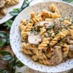 A bowl of creamy vegan mushroom pasta with fusilli pasta and chunky mushroom slices smothered in a creamy golden sauce.