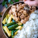 A plate of marinated five spice chicken with zucchini spears and rice.