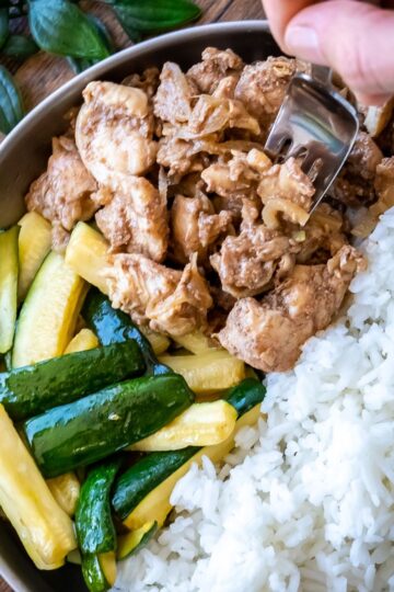 A plate of marinated five spice chicken with zucchini spears and rice.