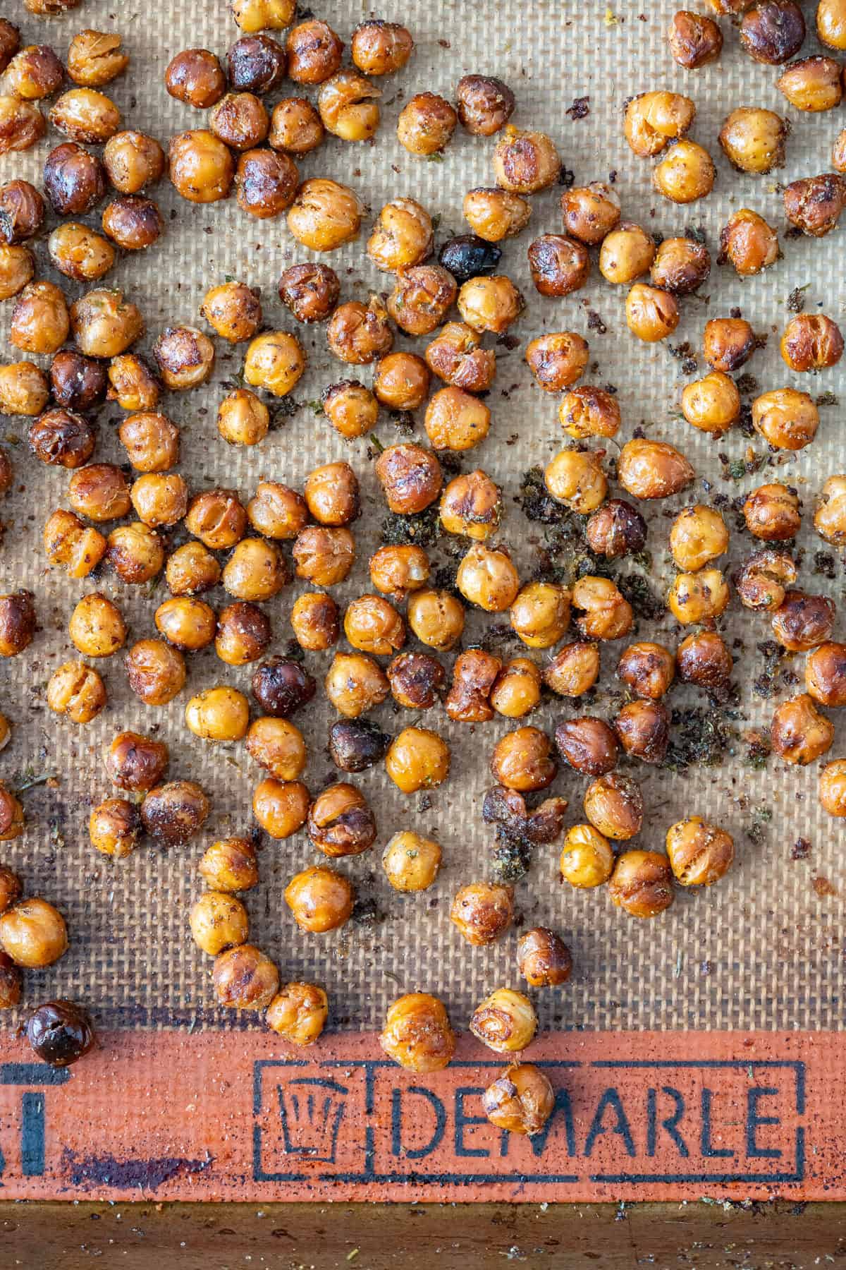 Finished crispy roasted chickpeas on a sheet pan lined with a silicone liner.