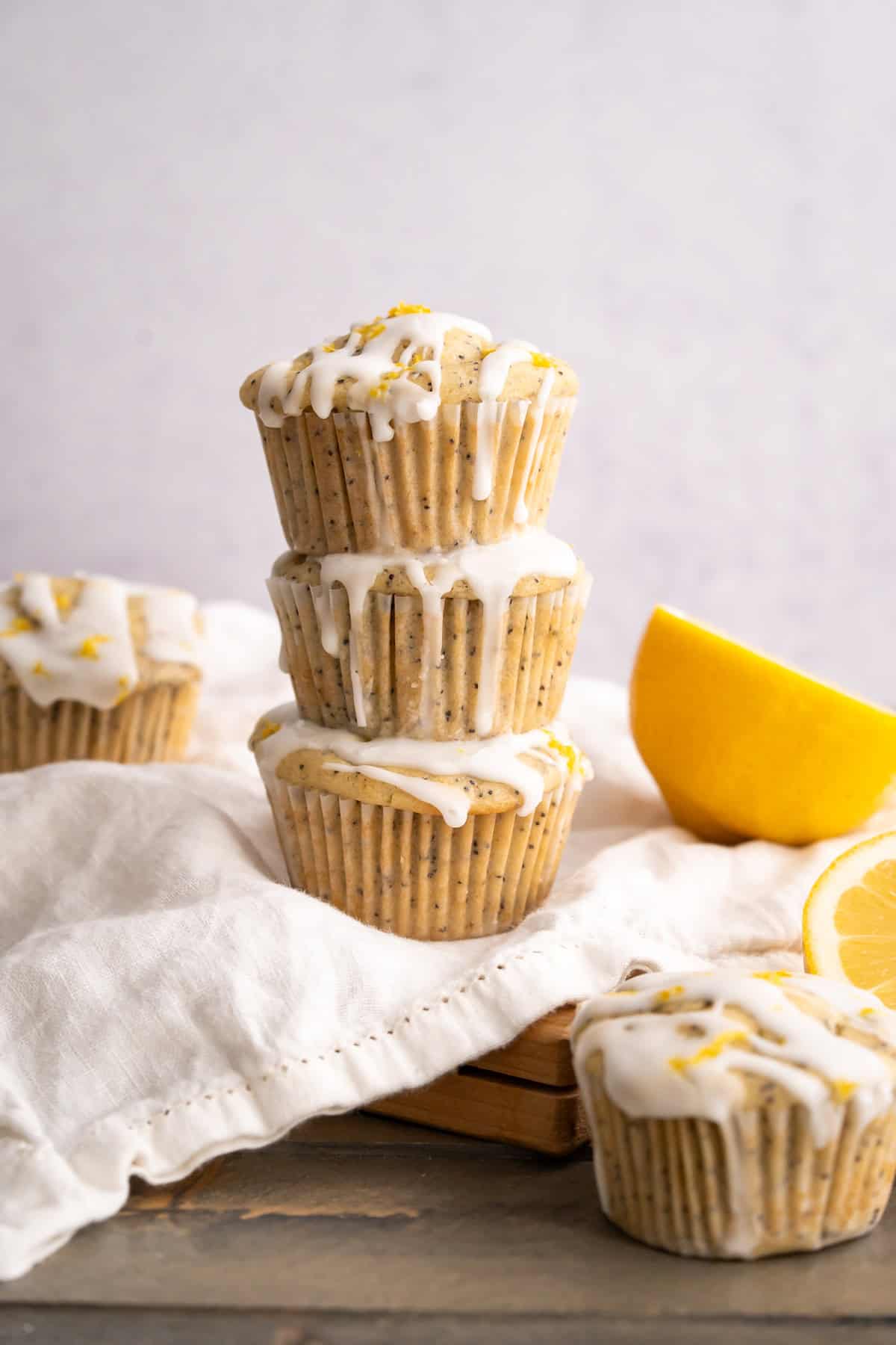 A stack of three gluten-free lemon poppyseed muffins to show the lemon glaze and round bakery-style tops.