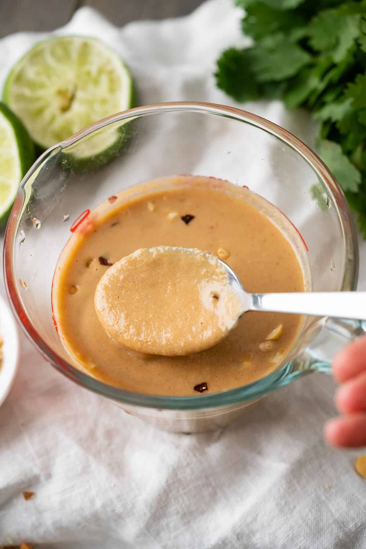 A close up of a spoon of Thai peanut butter sauce to show the creamy salad-dressing-like texture.