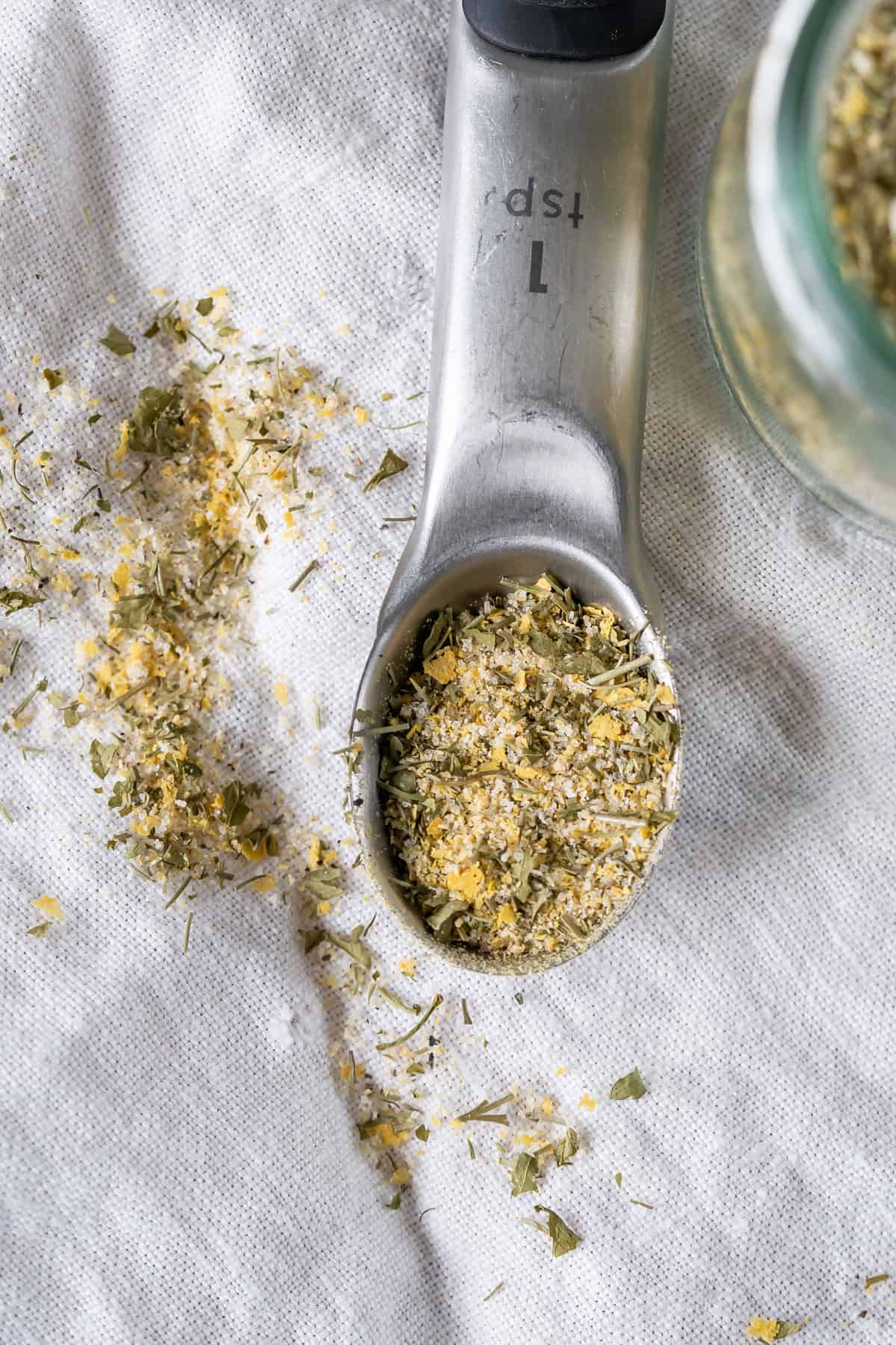 A close up image of homemade vegan ranch seasoning mix in a teaspoon.