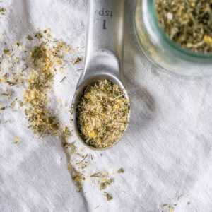 A close up image of homemade vegan ranch seasoning mix in a teaspoon.
