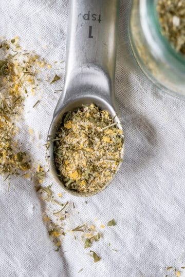 A close up image of homemade vegan ranch seasoning mix in a teaspoon.