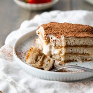 A slice of vegan tiramisu with layers of vegan ladyfingers and creamy vegan custard.