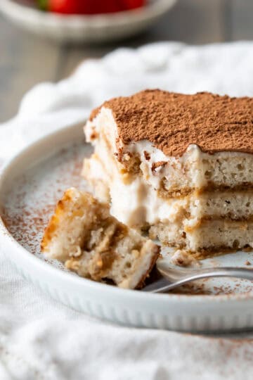 A slice of vegan tiramisu with layers of vegan ladyfingers and creamy vegan custard.