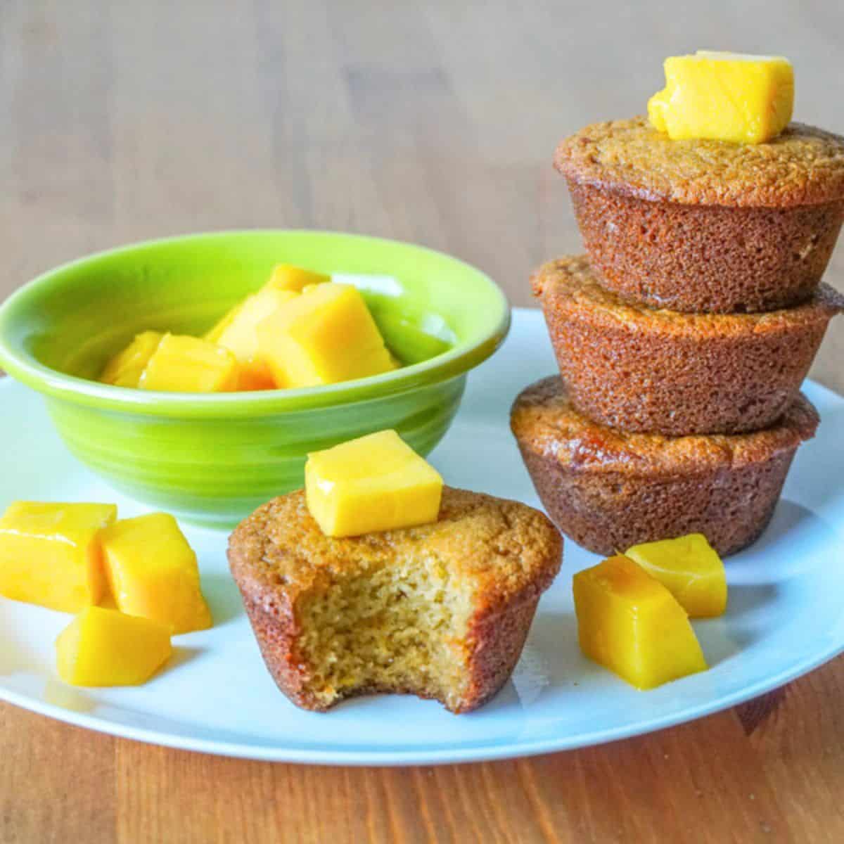 A stack of three golden brown mango muffins.
