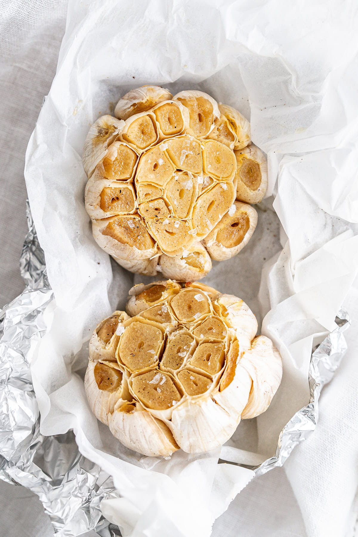 Two golden roasted garlic heads.