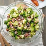 A prepared serving bowl of broccoli raisin salad with bacon.