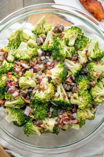 A prepared serving bowl of broccoli raisin salad with bacon.