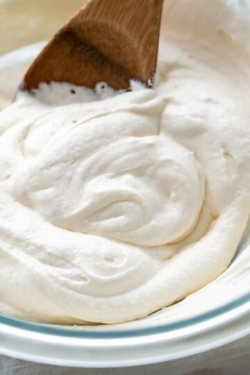 Creamy dairy-Free cream cheese frosting swirled in a bowl.