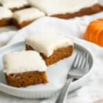 Two gluten-free pumpkin dessert bars arranged on a plate.