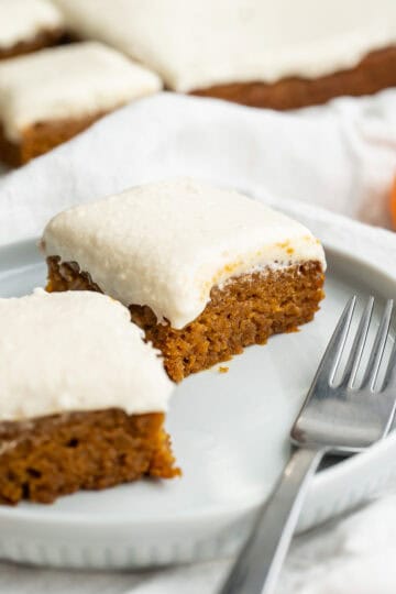 Two gluten-free pumpkin dessert bars arranged on a plate.