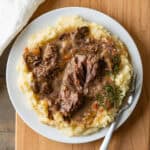 A serving of instant pot short ribs over garlic mashed potatoes.