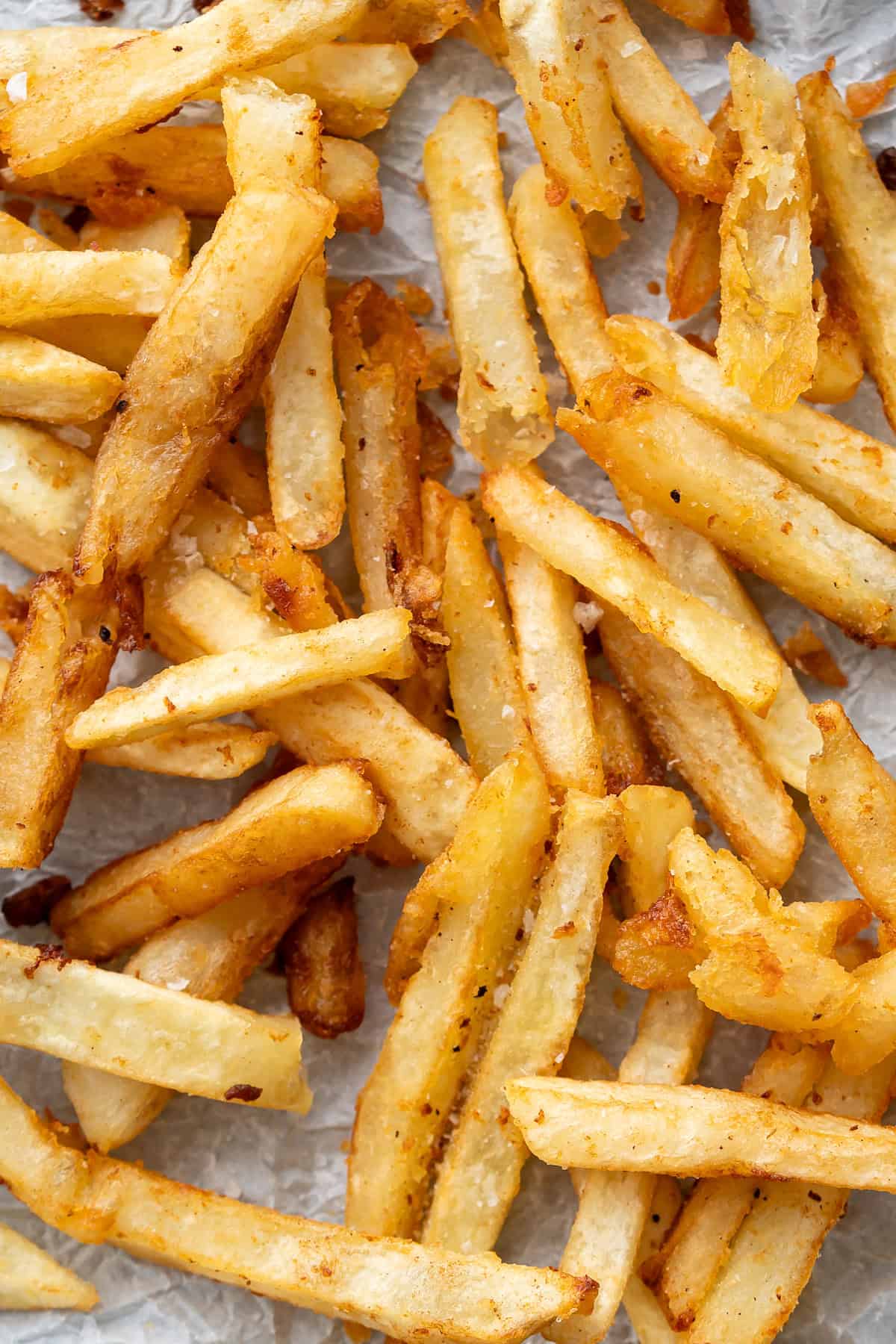 A close up of golden, extra crispy french fries.
