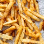 A close up of golden, extra crispy french fries.