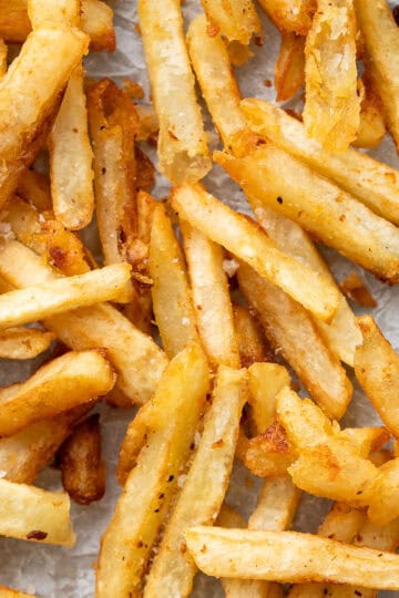 A close up of golden, extra crispy french fries.